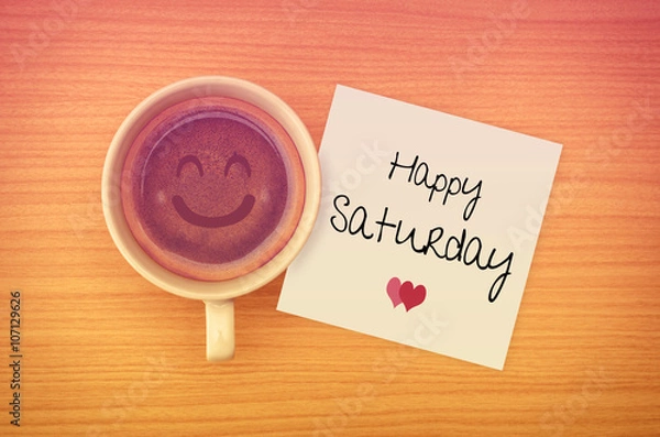 Obraz Happy Saturday on paper note with coffee cup,top view.