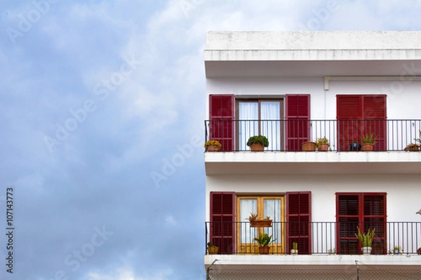 Obraz Classic latino spanish building facade with terrace and coloured windows with shutters