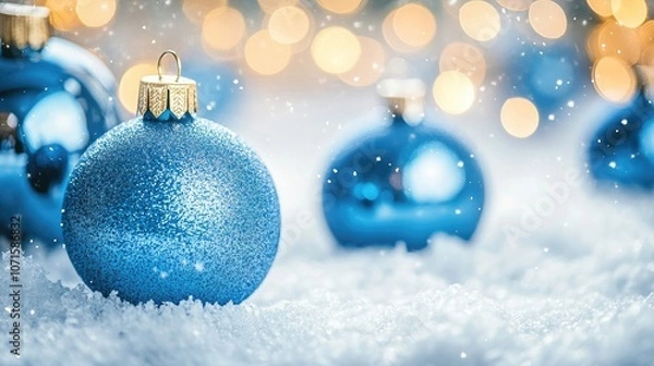 Fototapeta Classic blue glass Christmas decoration balls create a festive atmosphere in a close-up view, paired beautifully with soft snow, perfect for seasonal imagery and holiday themes.