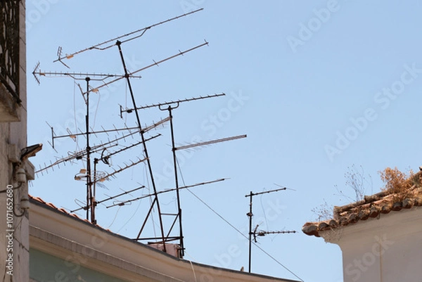 Fototapeta Multiple and messy analog terrestrial directional television antennas on a rooftop in Lisbon, Portugal