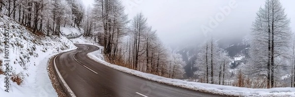 Fototapeta 
A panoramic view of an empty, winding road in the Alps in winter, with snow covering everything.