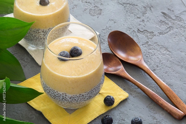 Fototapeta Homemade Chia seed pudding with banana and mango smoothie topped with blueberries