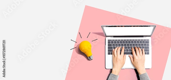 Fototapeta Person using a laptop computer and a light bulb - Flat lay