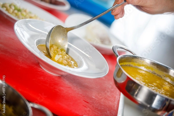 Obraz Chef is serving some white beans in a plate