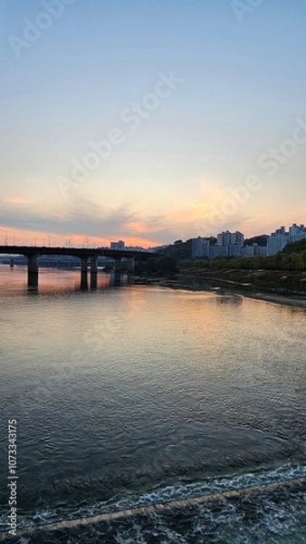Fototapeta 서울의 한강에서 노을지는 하늘과 불빛이 반짝이는 교량이 있는 도시 경관