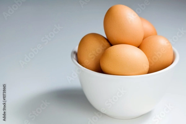 Obraz Świeże Brązowe Jaja W Białej Misce na Niebiesko-Szarym Tle