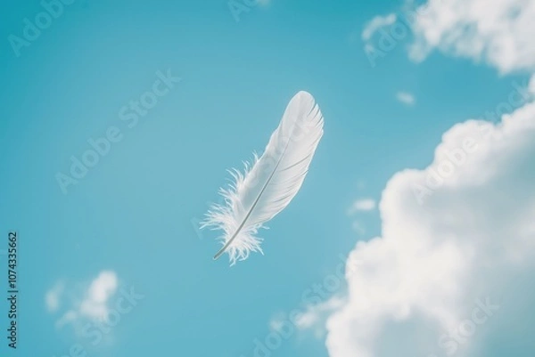 Fototapeta A single white dove feather floating peacefully in the sky with soft clouds