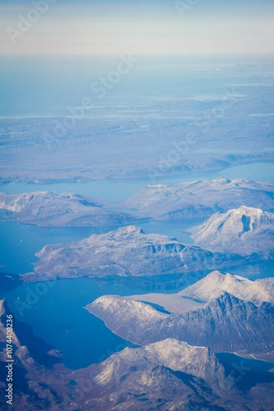 Fototapeta Greenlandic ice cap with frozen mountains and fjord aerial view