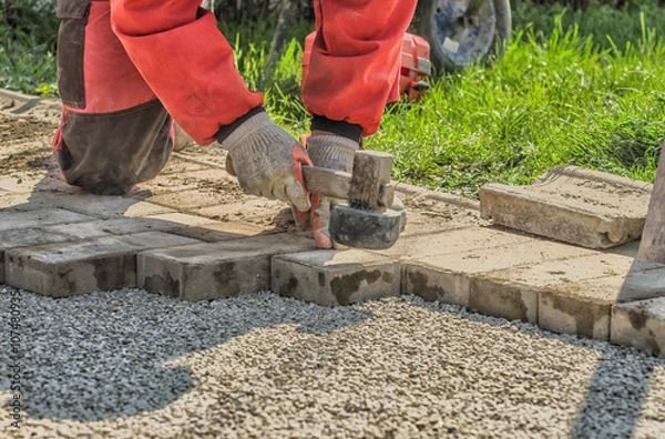 Obraz Worker paving a walkway