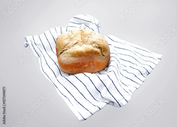 Fototapeta fresh bread lies on a white tablecloth