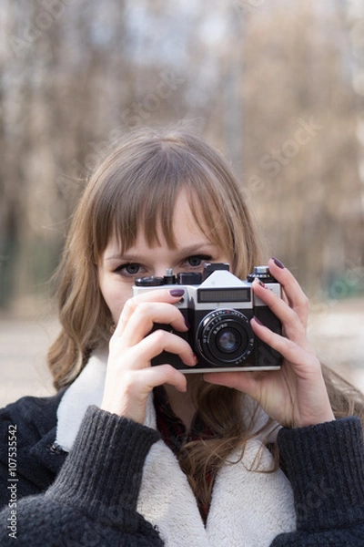 Fototapeta portrait of  pretty tourist taking photographs with vintage retro camera