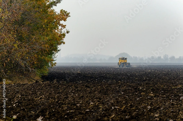 Fototapeta The tractor plows the land in autumn, for sowing. Image of agriculture