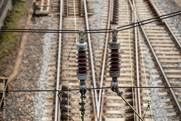 Obraz isolator on a power line for electric passenger trains in front of railway tracks