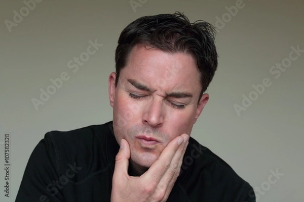 Obraz Man with toothache holding hand on face in pain