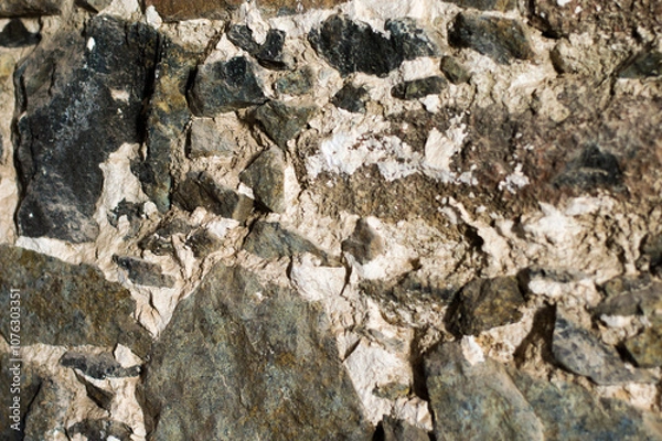 Fototapeta Rough textured closeup of rocky stone wall. Stony natural stone texture. Grunge background.