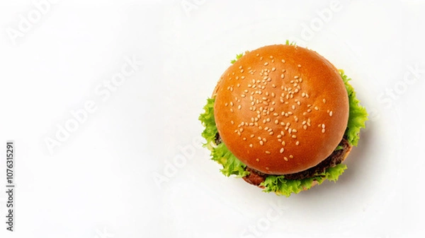 Fototapeta Top down view of a single hamburger bun on a plain white background. Сompositions for advertisements, or recipe visuals with room for customization