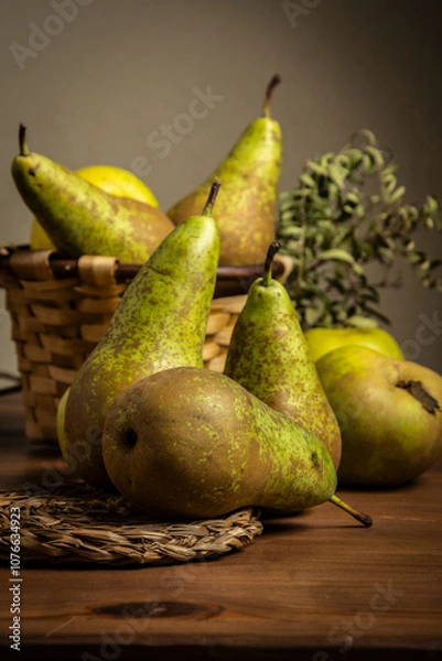 Fototapeta View of pears and basket on wooden table, dark background, vertical with copy space