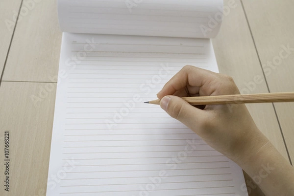 Fototapeta ノートと鉛筆　女の子の手　