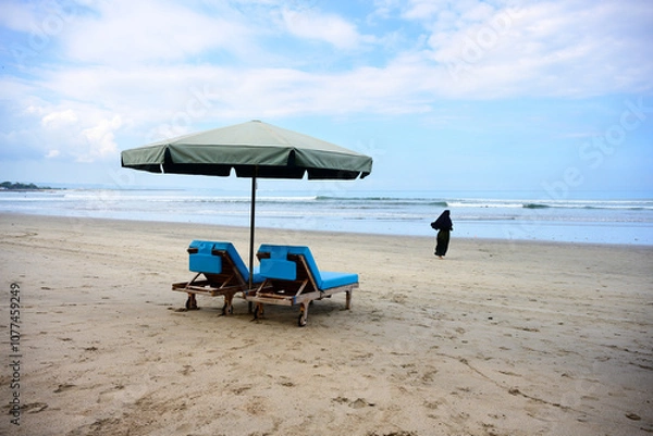Obraz Kuta Beach in Bali with Umbrella Parasol, Beach Lounger and a Running Muslim Woman Wearing a Hijab