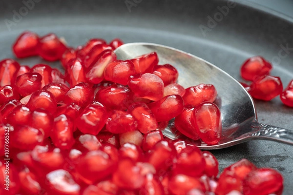 Fototapeta A silver spoon to eat pomegranate