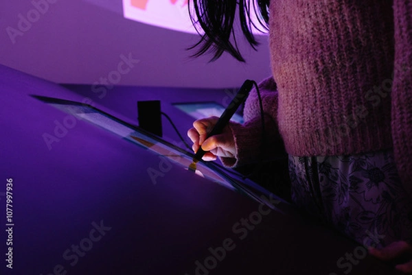 Obraz Woman drawing on interactive touchscreen with a stylus in a museum