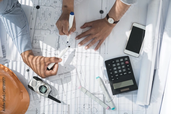 Fototapeta Hands of designers discussing project of apartment, view from above