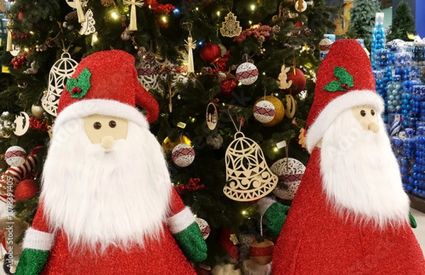 Obraz Two cute Santa Clauses near the Christmas tree.