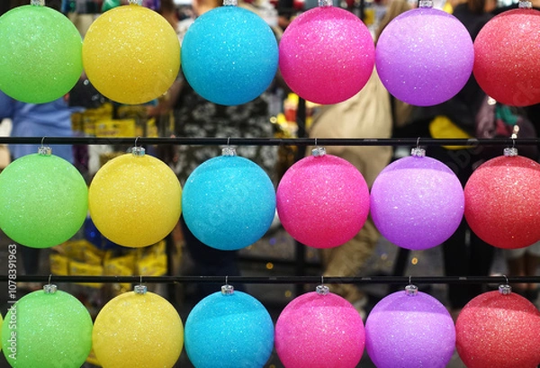 Obraz Rows of colorful Christmas balls hang on a stand