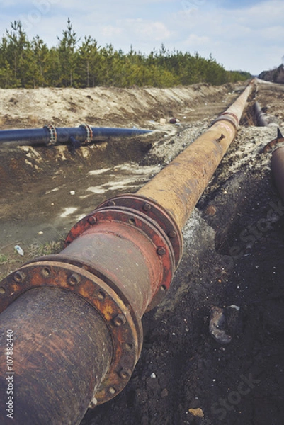 Fototapeta Steal big pipeline on a ground. Old pipes joint.

