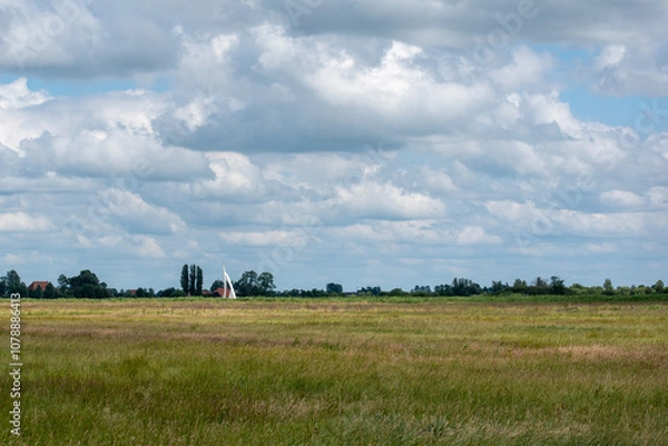 Obraz Typical Dutch polder landscape with clouds and sailboat at nature reserve Bloksloot (Bloksleat), Friesland, the Netherlands