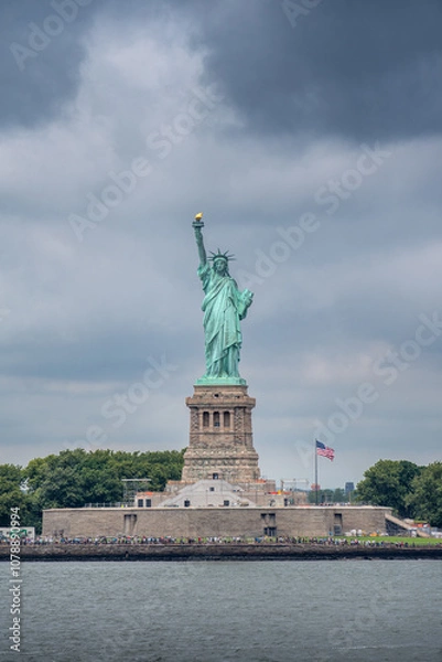 Fototapeta Statue of liberty on liberty island in New York with a cloudy sky