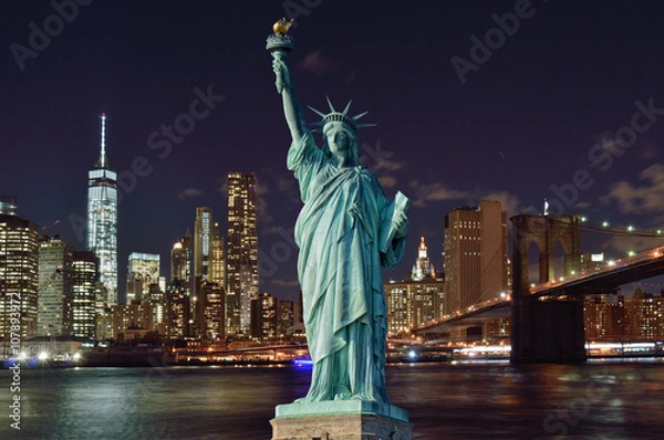 Fototapeta Manhattah skyline with Brooklyn Bridge at night and Statue of Liberty.