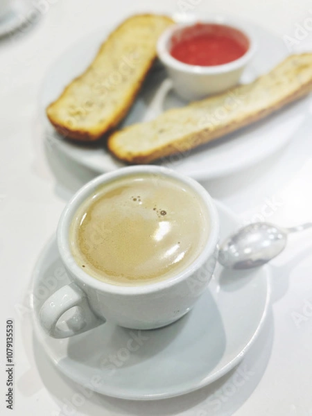 Obraz A white cup of espresso coffee and toasted bread with fresh tomato pasta for breakfast are on the table. Vertical image. Traditional Spanish breakfast.
