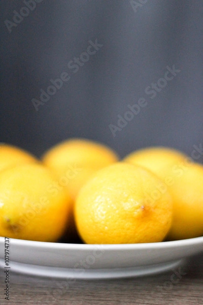 Obraz Lemons in a dish with a simple background