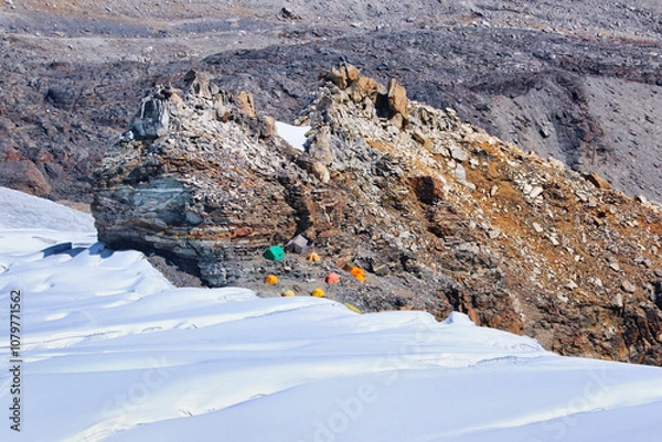 Fototapeta Mera Peak High Camp expedition tents and mess tents sheltered under a large rock off the Mera snowfields seen on descent from the summit of Mera Peak central,6461 m,Mera Peak Expedition,Nepal 