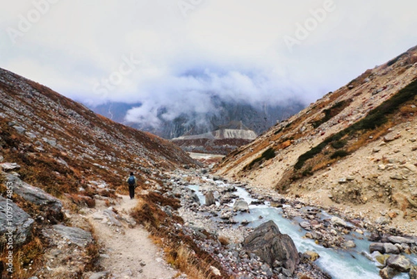 Fototapeta Rocky mountain trail rises over rocky glacial terrain following the Hinku river up to Khare village on route to the  Base camp of Mera Peak,a 6476 meter high peak in the Khumbu Himalayas,Nepal