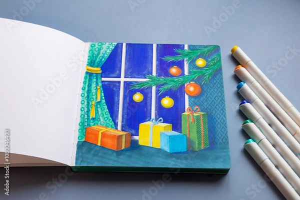 Fototapeta Drawing with markers in a sketchbook on the Christmas theme - a Christmas tree with decorations and gifts