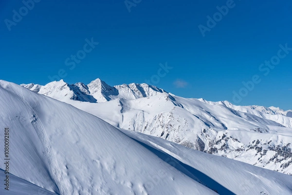 Fototapeta Beautiful landscape of the Arkhyz ski resort with mountains, snow, forest on sunny winter day. Caucasus Mountains, Russia.
