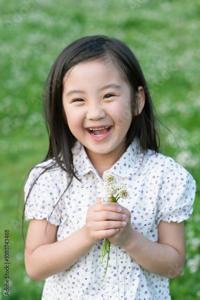 Obraz 嬉しそうにシロツメクサの花束を持つ女の子