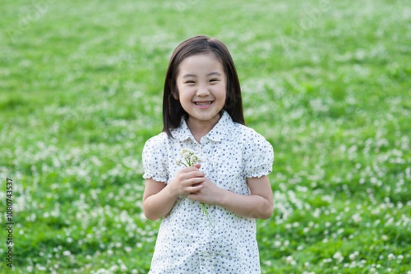 Obraz 嬉しそうにシロツメクサの花束を持つ女の子