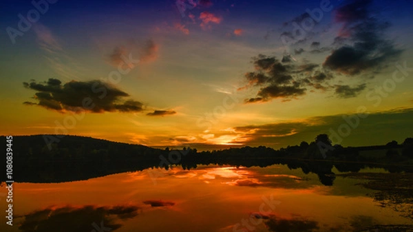 Fototapeta lake at sunset in the clouds