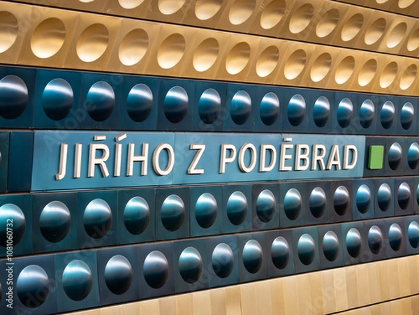 Obraz Jiřího z Poděbrad metro station in Prague, Czechia. Sign of the location name in the subway tunnel. Yellow and blue aluminum shapes are mounted to the wall. Public transportation in the big city.