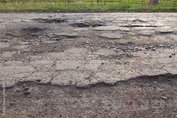 Fototapeta pits and potholes on asphalt road. The bad broken road