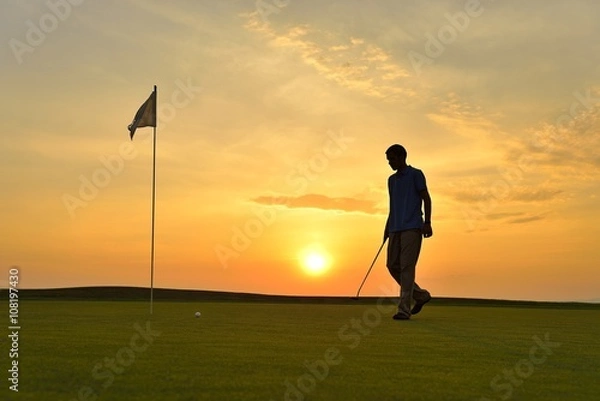 Obraz Young man playing golf at sunset