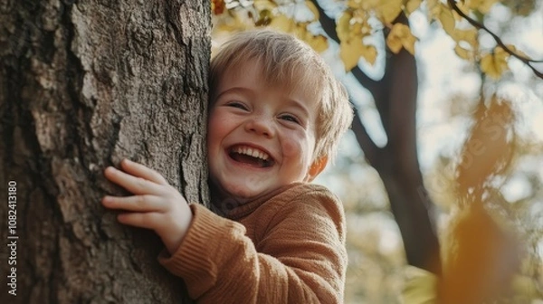 Fototapeta Joyful Child with Down Syndrome Playing Hide and Seek Behind Tree in Park - Photorealistic Portrait of Happiness in Inclusion