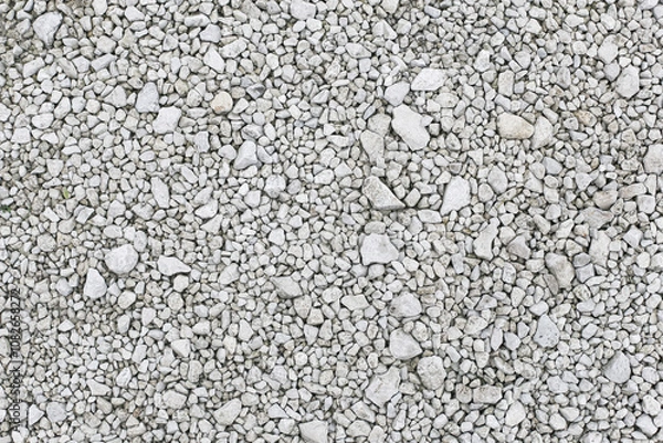 Fototapeta Gravel stones texture. Natural gray noise backdrop. Bright white and gray crushed stone pebbles form a decorative surface. Backyard patio garden path. Grunge pattern ground. Crushed rocks.