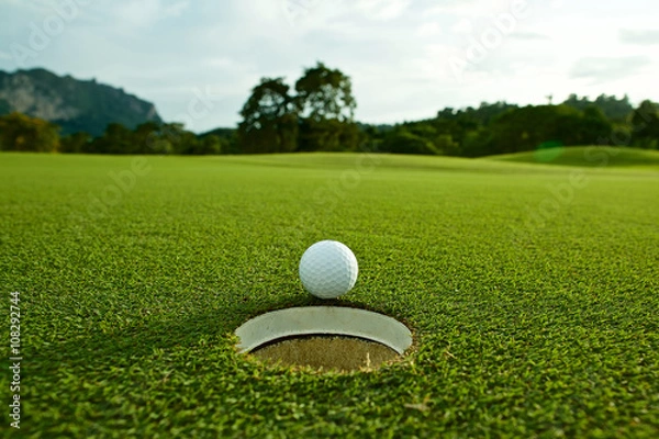 Fototapeta zdjęcie flary białej piłki golfowej w pobliżu dołka na torze wodnym w