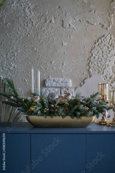 Obraz Christmas table composition made of fresh nobilis spruce, white candles, pine branches with glass balls and decorative gold deer. Happy New Year decorations.