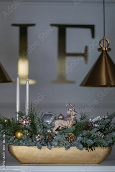 Obraz Christmas table composition made of fresh nobilis spruce, white candles, pine branches with glass balls and decorative gold deer. Happy New Year decorations.