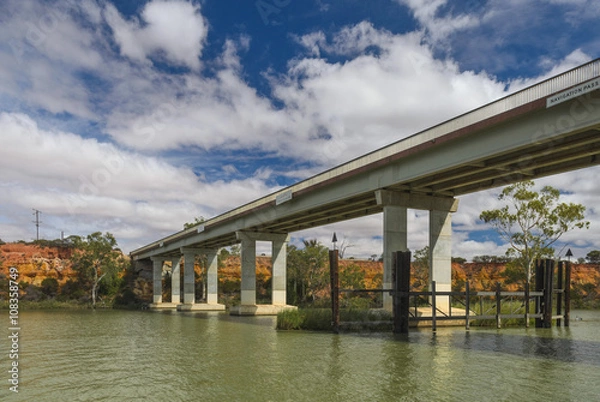 Fototapeta Concrete highway bridge arcoss river cliffs at waterfront